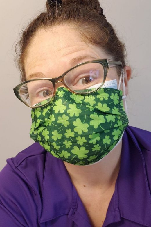 MollieShea wearing a mask patterned with clovers